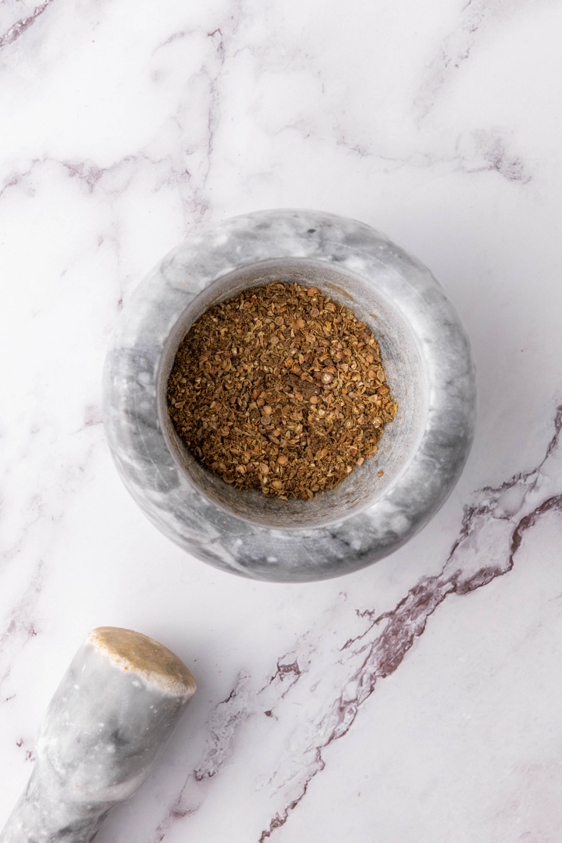 Freshly ground cumin, coriander, oregano, cloves, and peppercorns for birria seasoning.