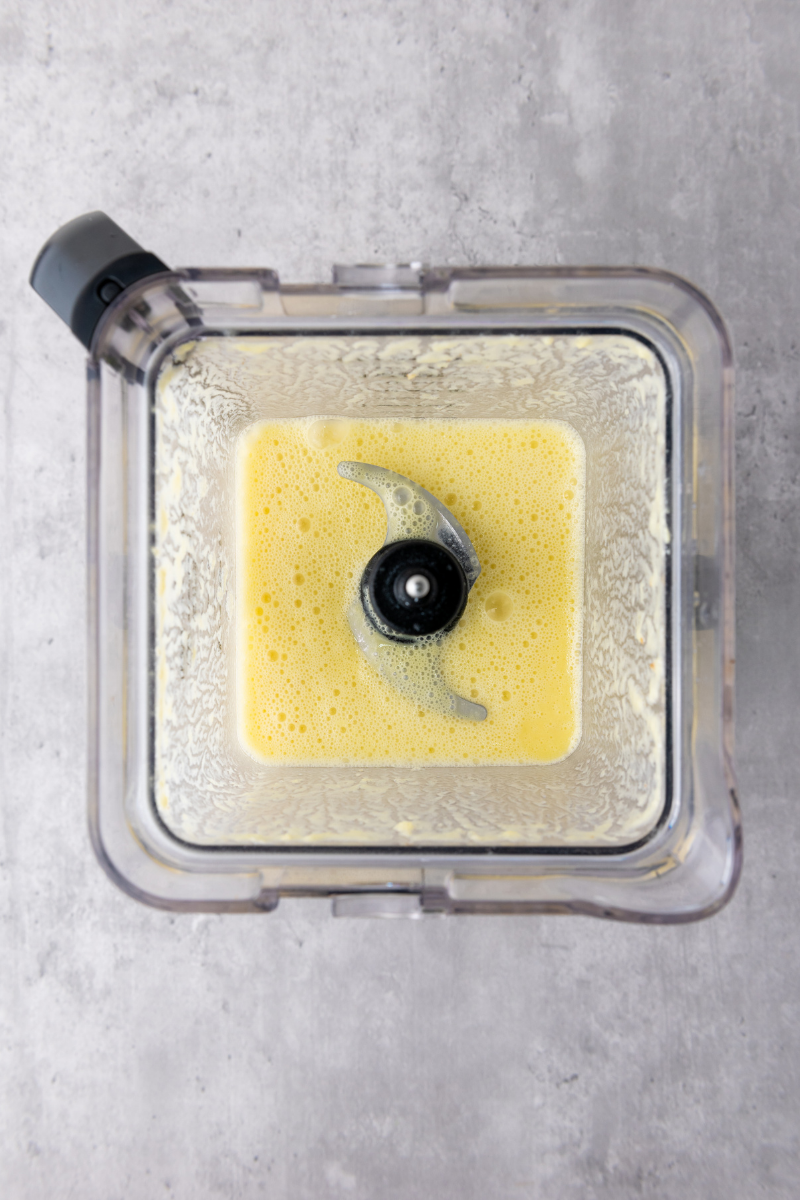 Fresh lime juice added to pineapple and coconut mixture in a blender.