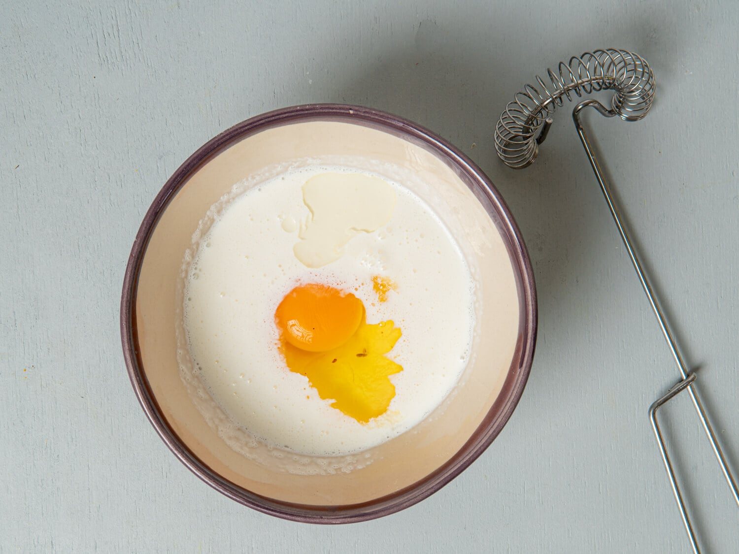 Heavy cream, sour cream, egg and orange flavorings combined in a bowl for cranberry scone dough.