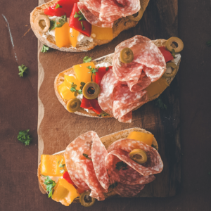Salami Bruschetta with Roasted Peppers, Goat Cheese, and Olives