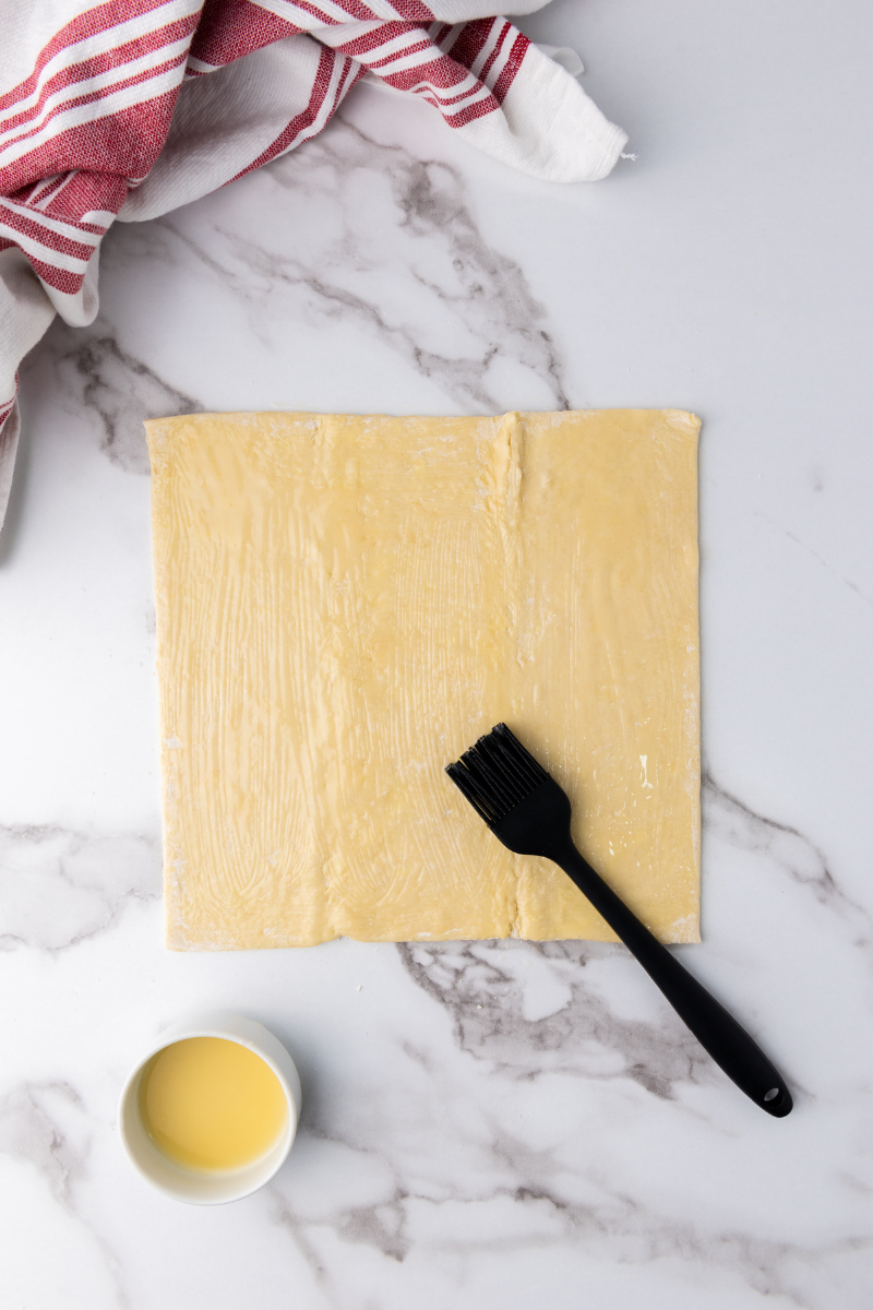  Puff pastry sheet brushed with butter before adding cinnamon sugar and apples.