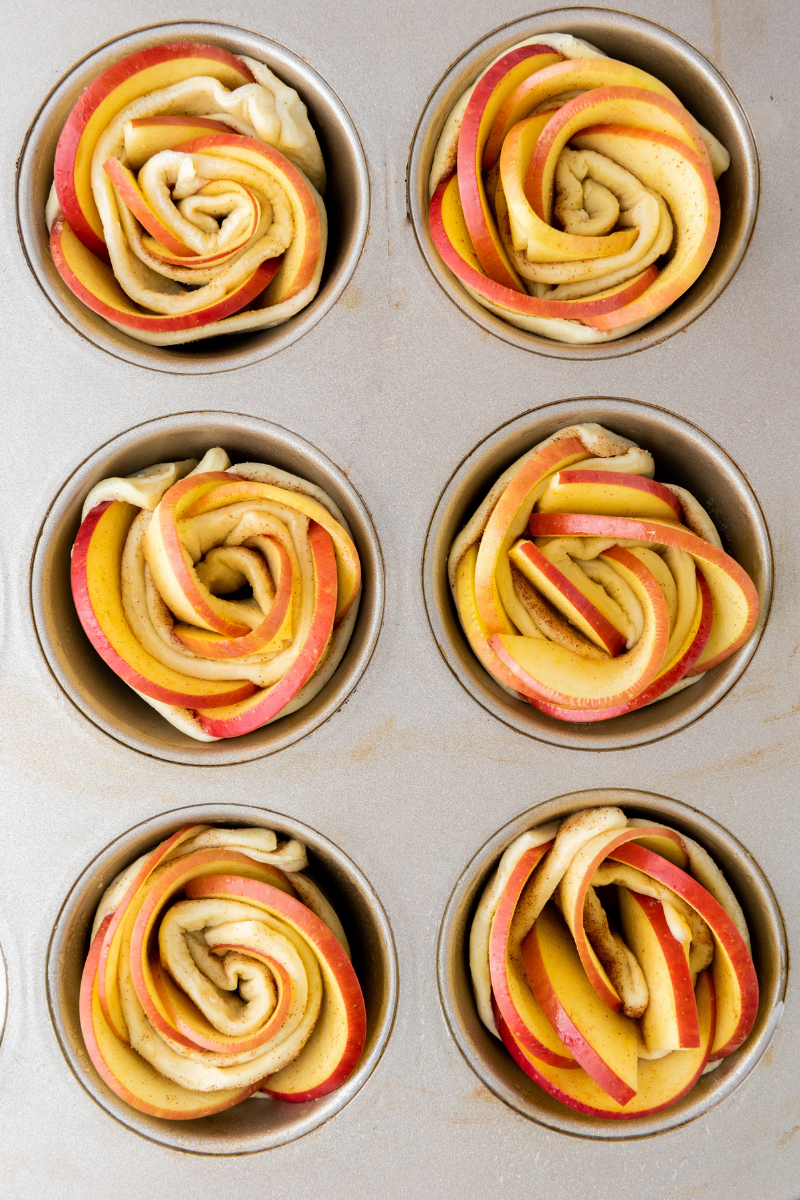 pple rose puff pastries arranged in a muffin tin before baking.