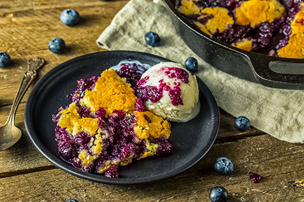 Easy blueberry cobbler served warm with vanilla ice cream, juicy blueberry filling and golden crust on a plate