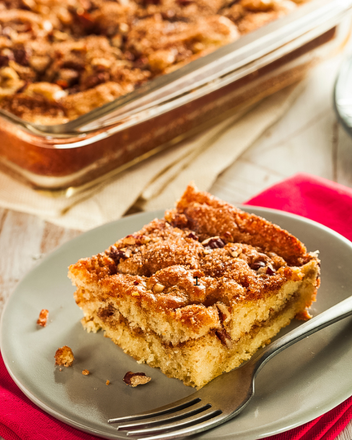 Moist cinnamon coffee cake with crumb topping on a white plate”