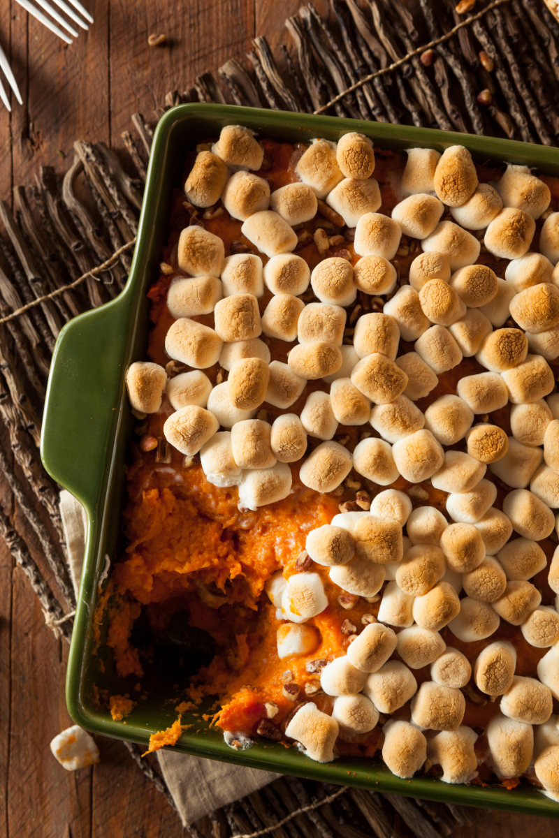 Baked sweet potato casserole in a casserole dish with golden toasted marshmallows on top.