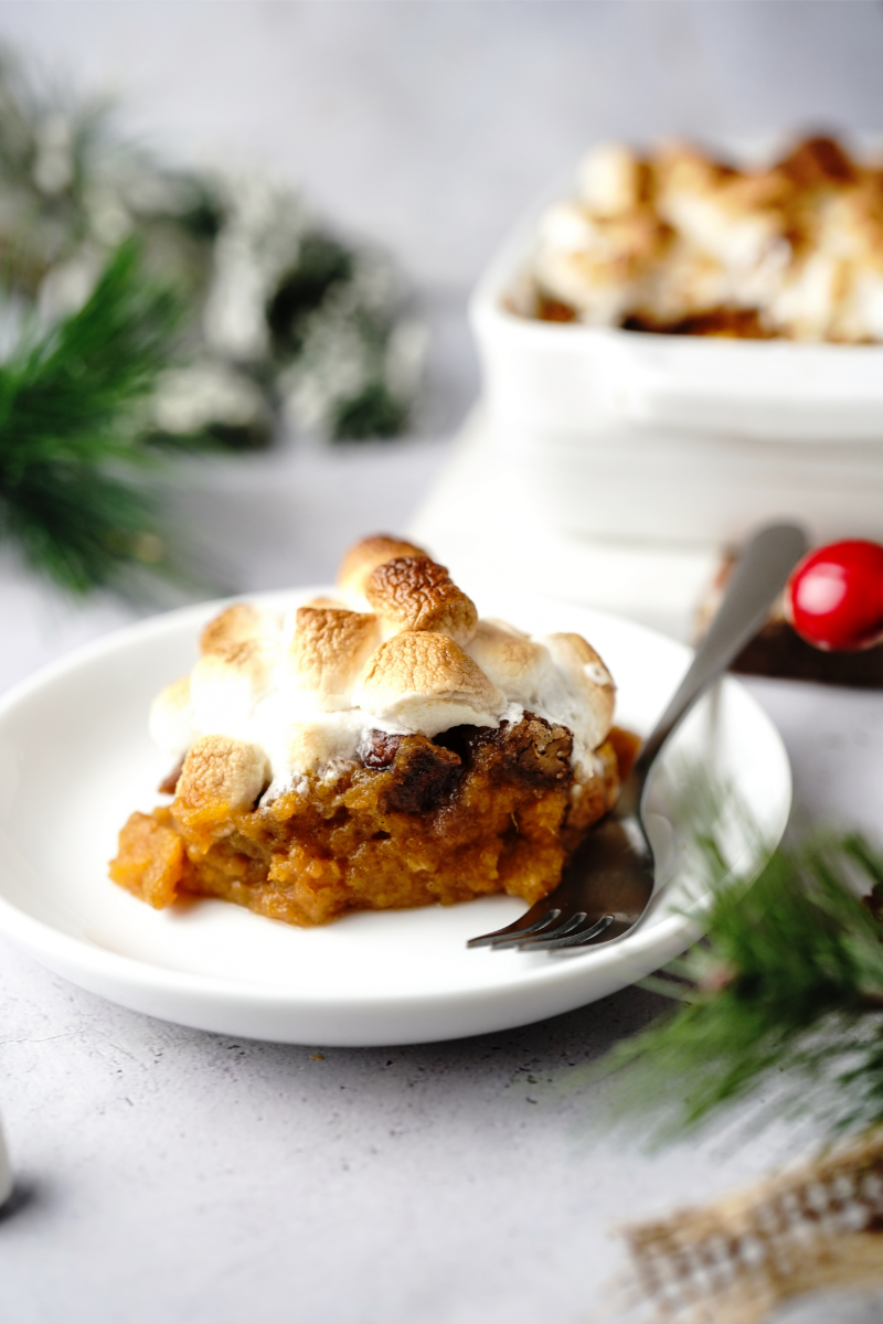 Baked sweet potato casserole in a casserole dish with golden toasted marshmallows on top.
