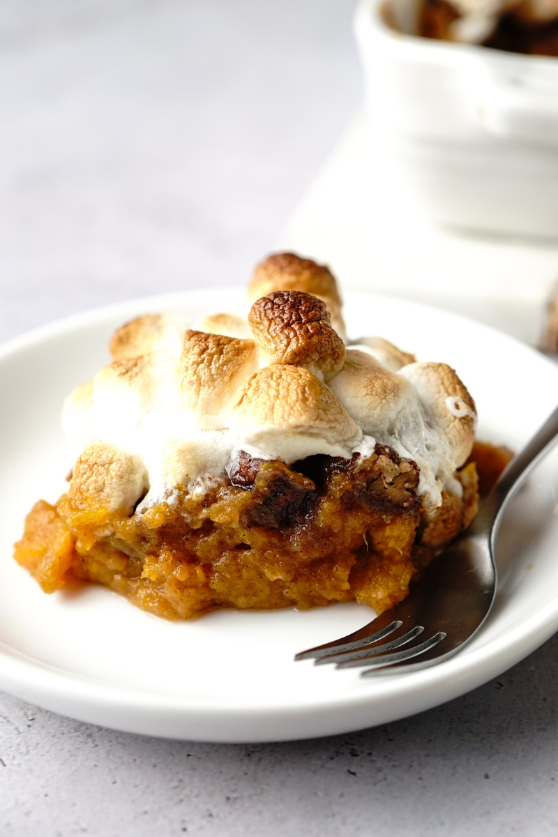 Baked sweet potato casserole in a casserole dish with golden toasted marshmallows on top.