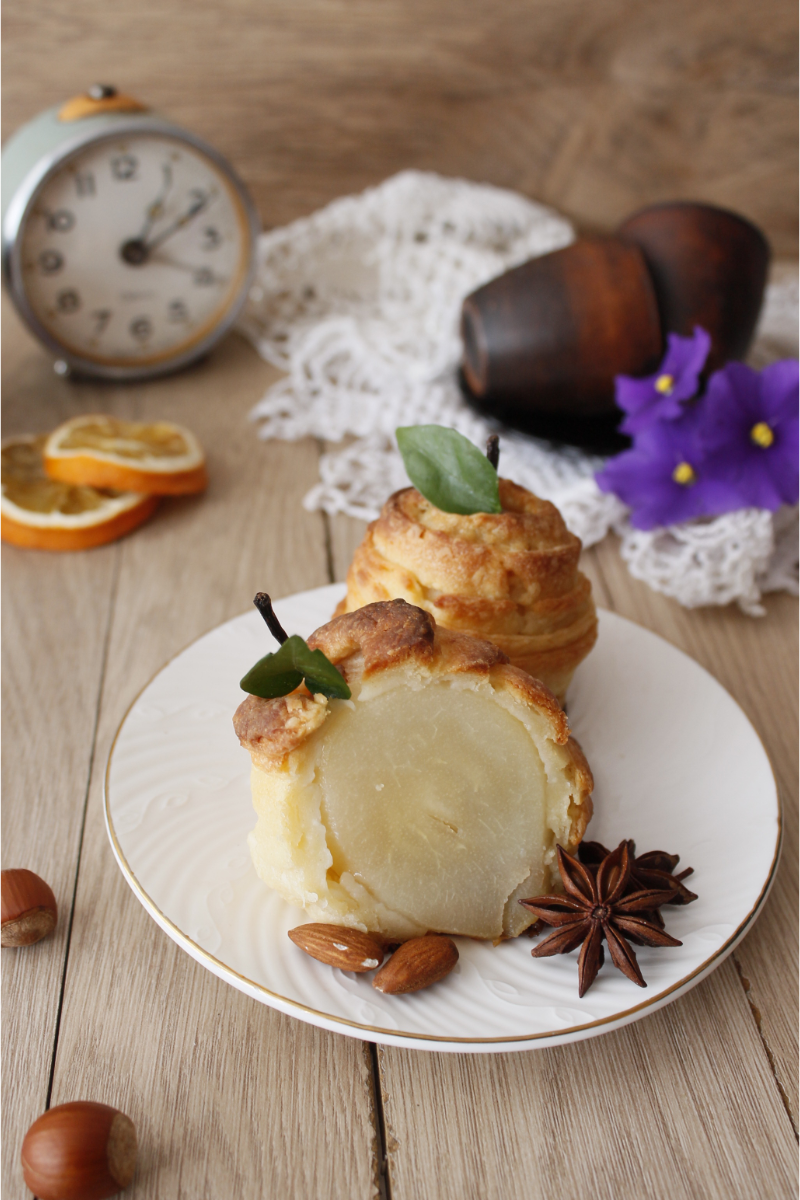 Close-up of a puff pastry strip-wrapped pear cut open to show tender fruit inside