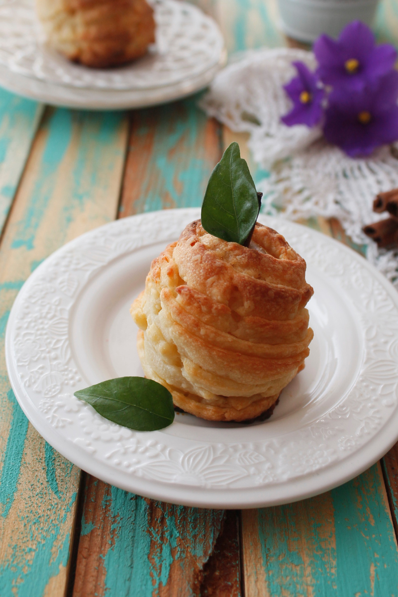 Pears wrapped in puff pastry strips, baked golden on a serving plate