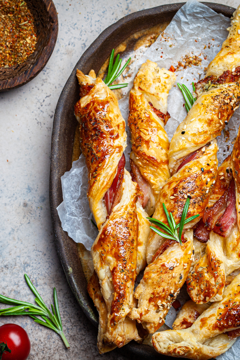 Platter of crispy cheese and bacon breadsticks served with dipping sauces and fresh herbs