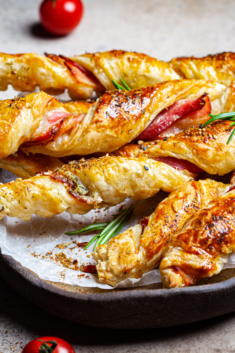 Platter of crispy cheese and bacon breadsticks served with dipping sauces and fresh herbs