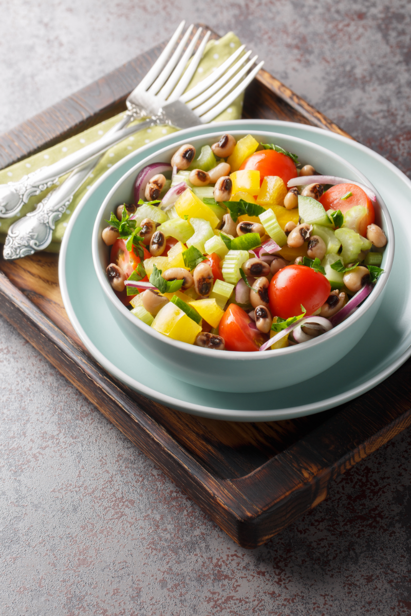 Side-angle view of Mediterranean black-eyed pea and vegetable salad in a bowl, highlighting fresh chopped vegetables
