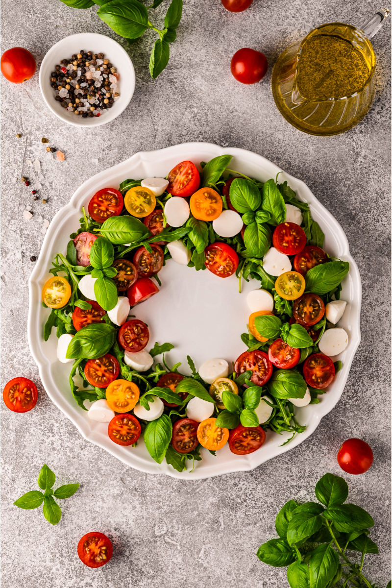 Christmas Caprese Salad with arugula, mozzarella, cherry tomatoes, and balsamic glaze”