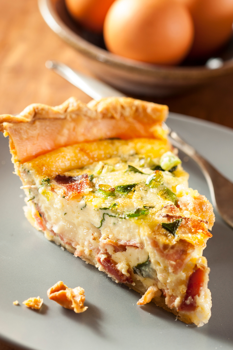 Golden-baked Spinach and Bacon Egg Quiche fresh out of the oven, with a fluffy custard and crispy bacon bits on top
