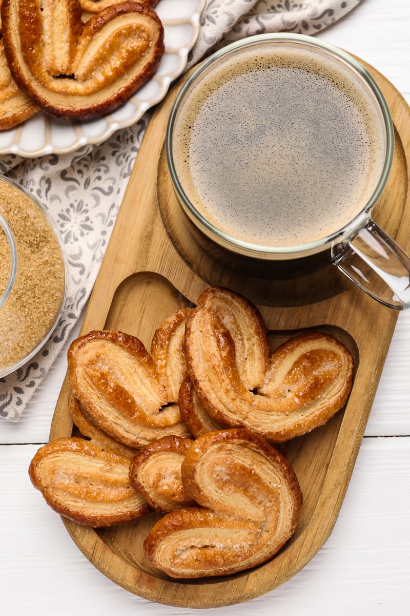 Close-up of caramelized French elephant ear cookies on a rustic plate, showing flaky layers and golden color.