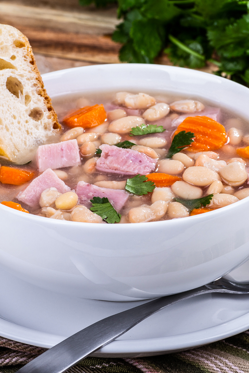 Rustic bowl of healthy white bean and ham soup, warm and comforting with beans, ham, and aromatic herbs