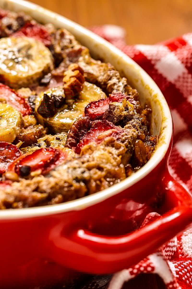 Healthy strawberry banana baked oatmeal with golden edges and visible oats, served family-style