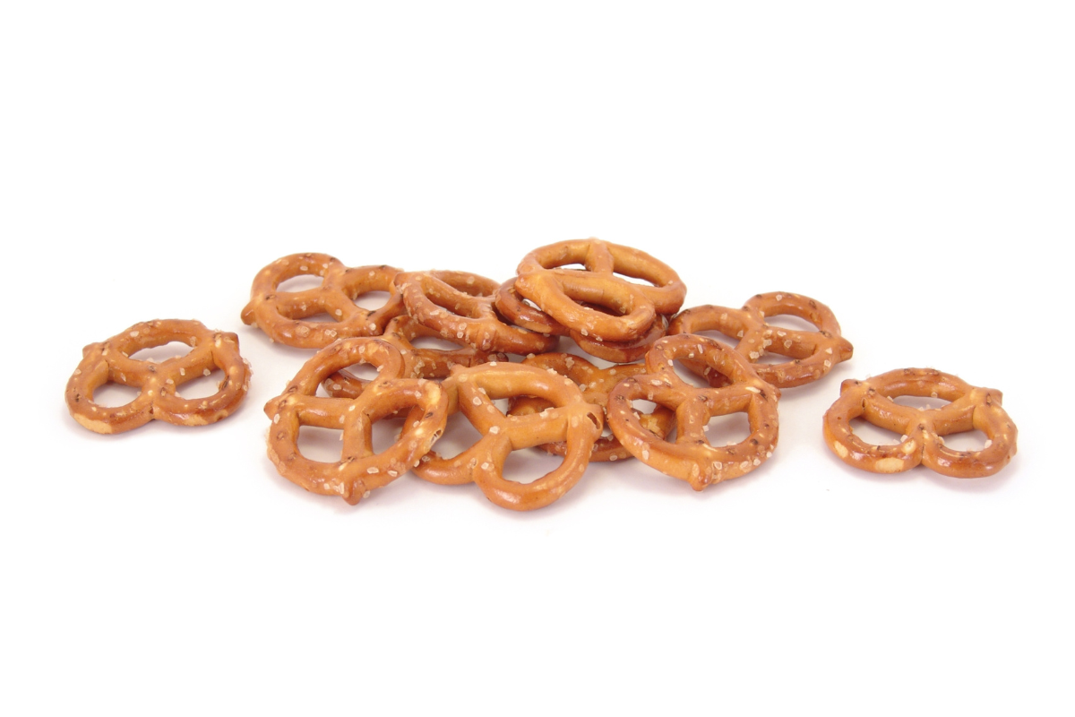 Salted pretzels scattered on a light background, crisp and golden brown snack pieces.