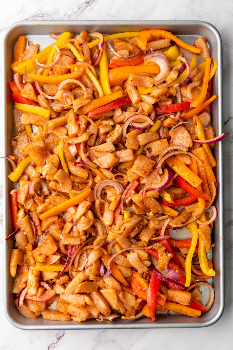 Roasted sheet pan chicken fajitas fresh from the oven with tender chicken, caramelized peppers, onions, and golden edges.
