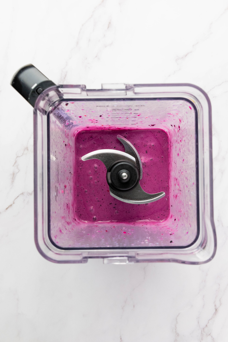 Thick purple smoothie bowl mixture blended until creamy in a high-speed blender.