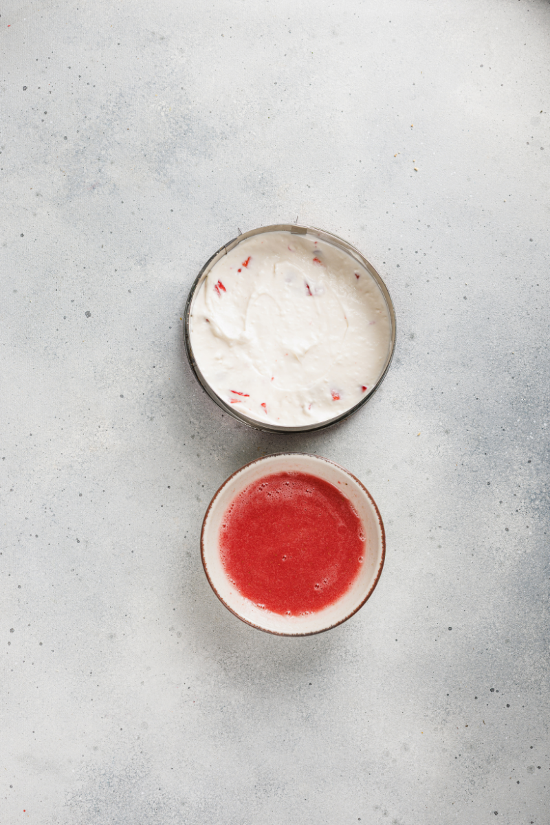 No-bake strawberry cheesecake assembled in a springform pan with strawberry topping ready to spread.