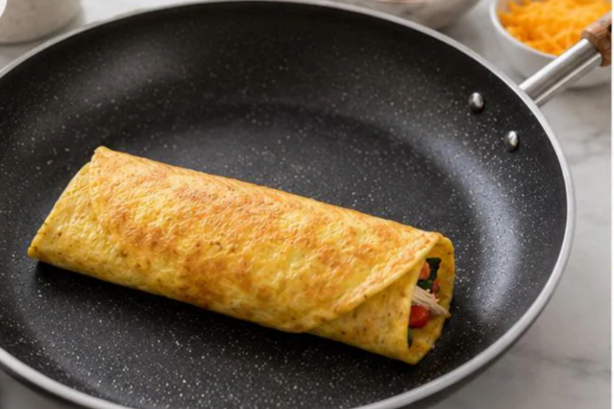 Finished breakfast egg wrap folded and resting seam-side down in skillet