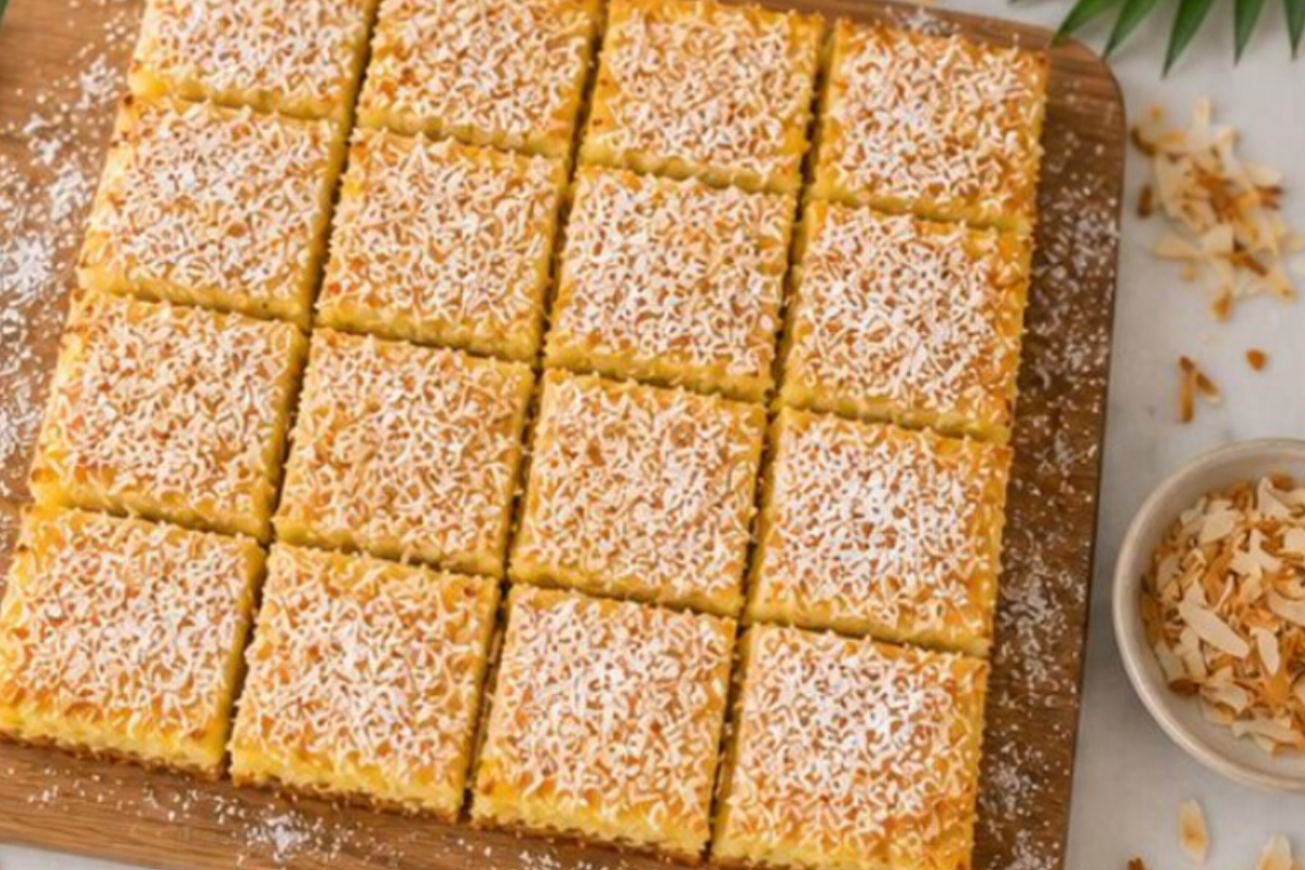 Finished pineapple bars cut into squares and dusted with powdered sugar.