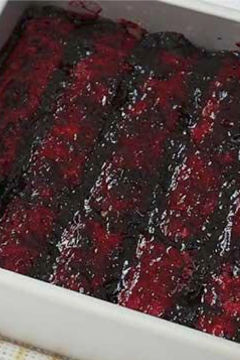 Finished blueberry topping spread across layered blueberry tiramisu before chilling