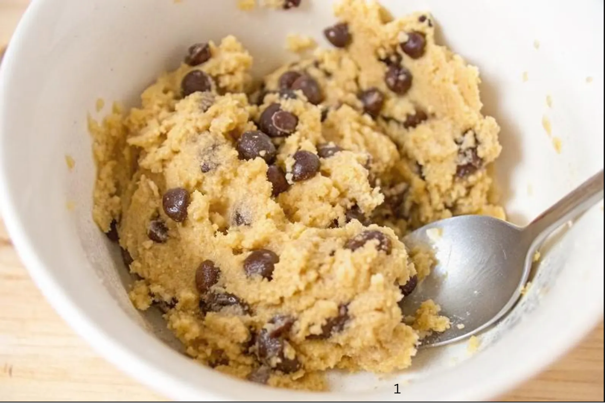No-bake chocolate chip cookie dough mixture prepared in a white bowl with a spoon.