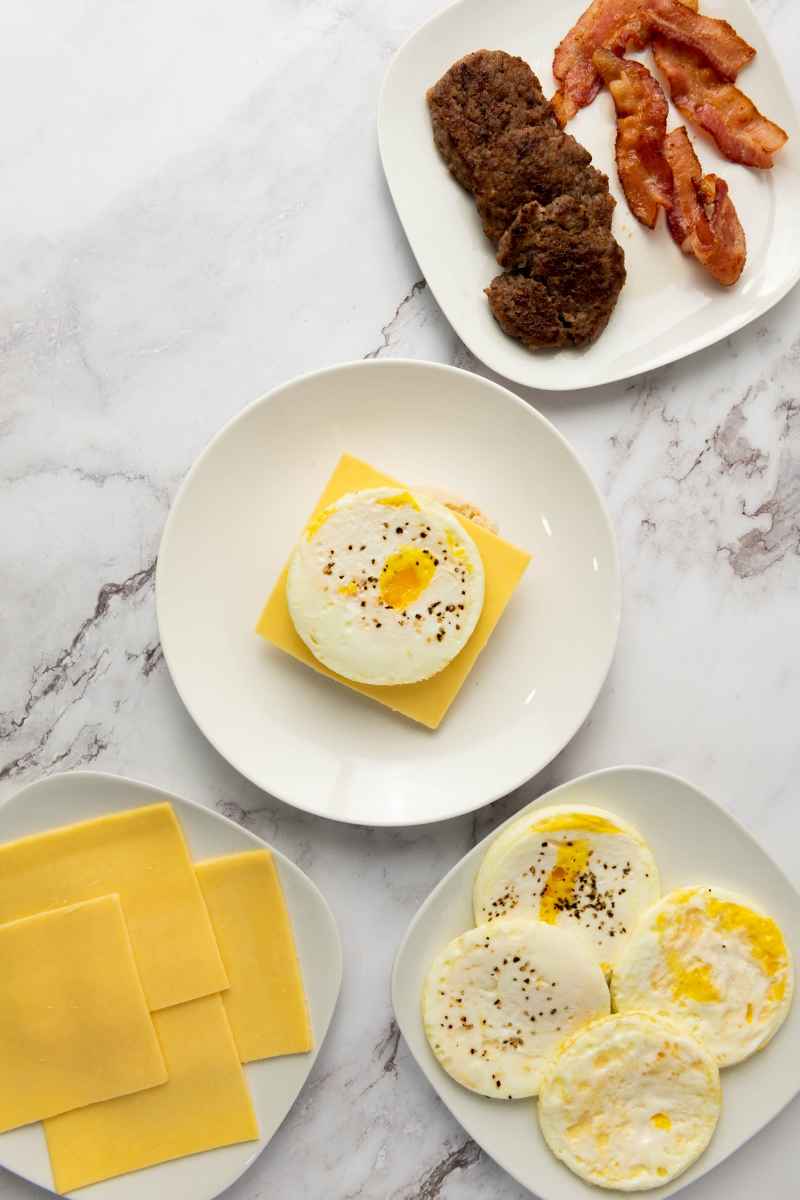 Cooked egg layered over cheese on an English muffin.