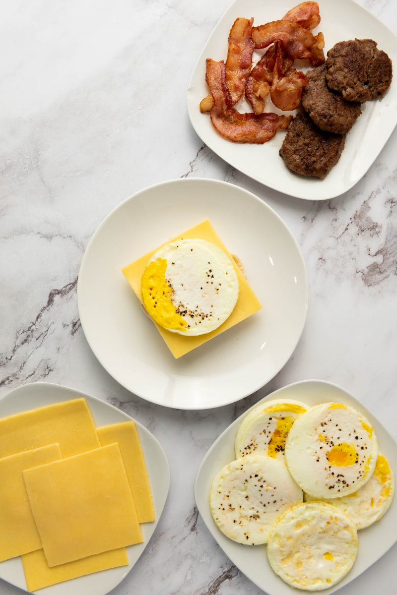 Cooked round egg layered over cheese on an English muffin.