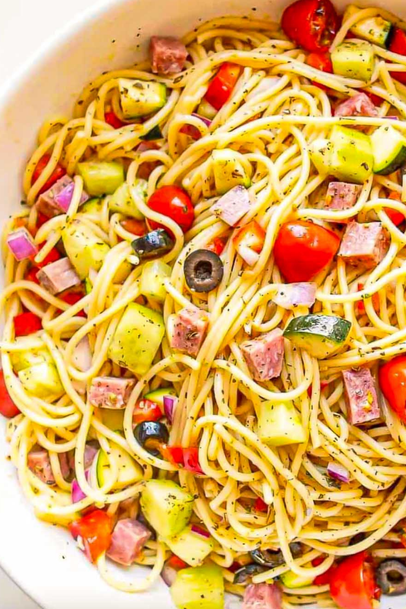 Chilled Spaghetti Salad garnished with fresh parsley and Parmesan cheese, perfect for potlucks and summer BBQs.