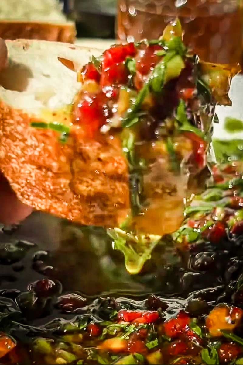 Finished smoky Mediterranean bread dip with chopped vegetables, olives, and herbs, ready to serve.