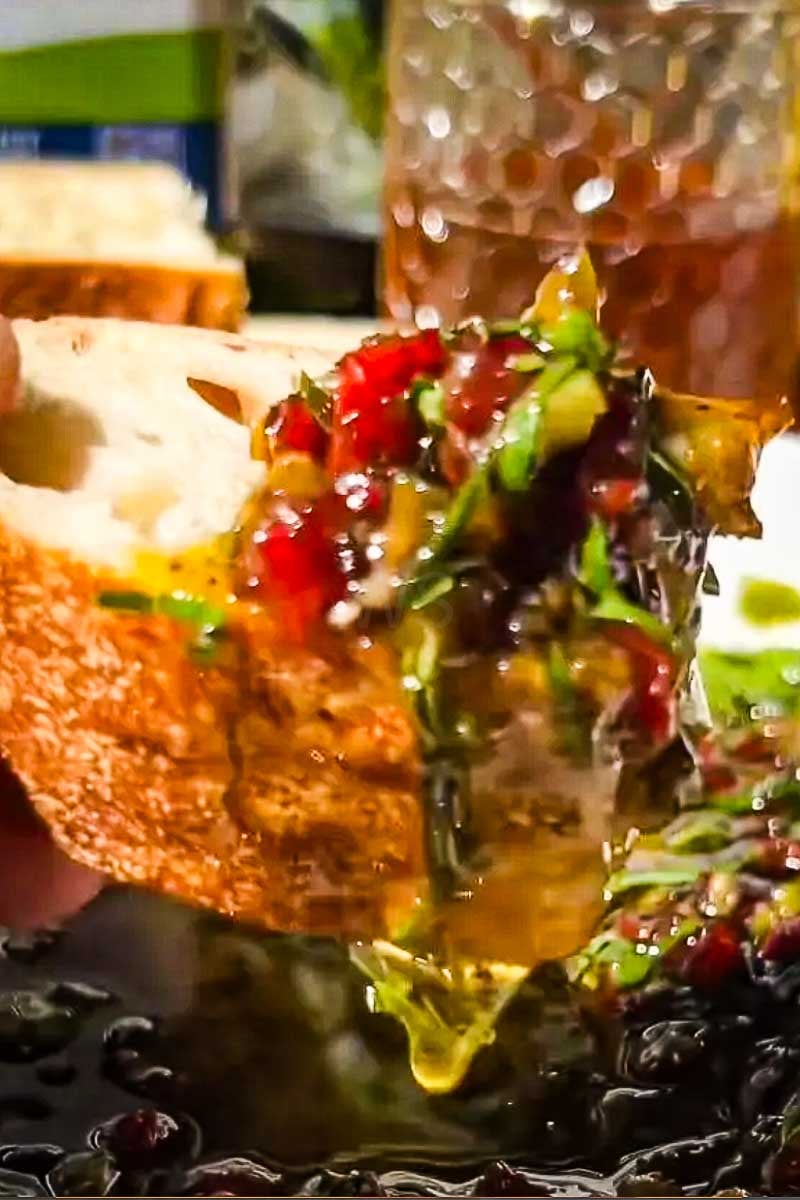 Mediterranean bread dip with tomatoes, bell peppers, and herbs in balsamic olive oil.