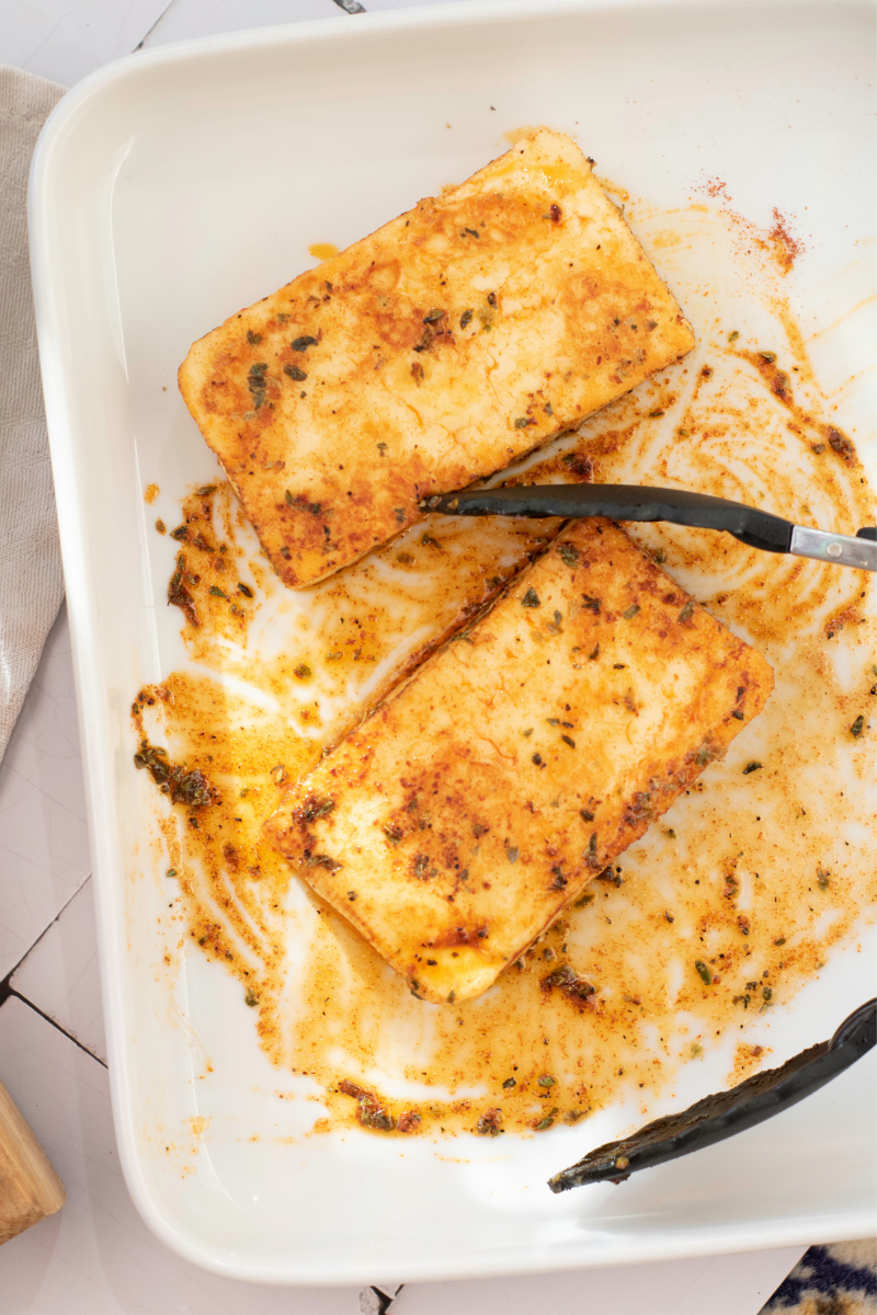 Crispy golden halloumi slices resting on a plate after pan-frying for halloumi burgers.