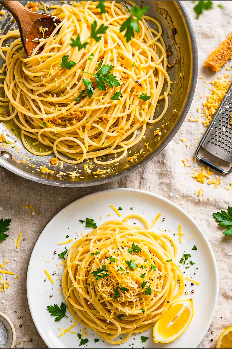 Close-up of silky spaghetti tossed with bottarga, fresh lemon, parsley, and olive oil in a Mediterranean-style pasta dish.