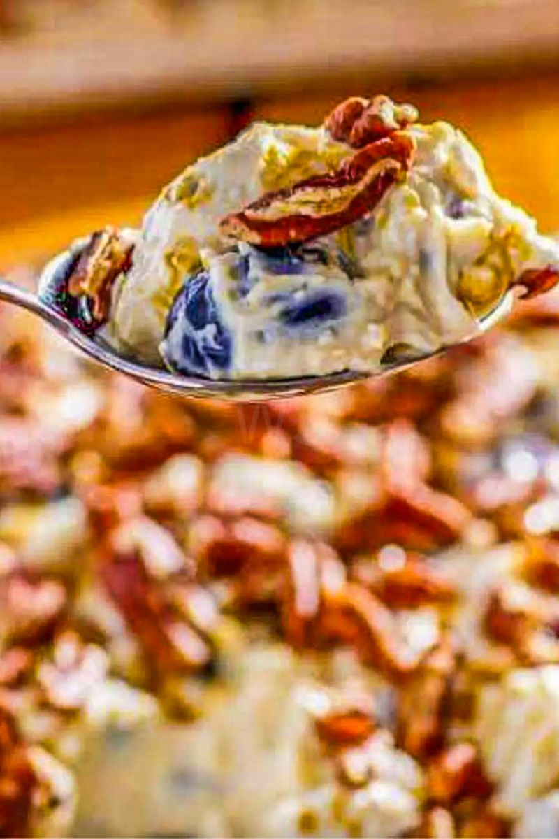 Spoonful of creamy Southern grape salad with seedless grapes, brown sugar and chopped pecans.