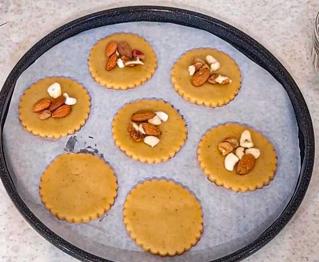Chopped walnuts, almonds, cashews, and pistachios pressed onto unbaked baklava cookies.