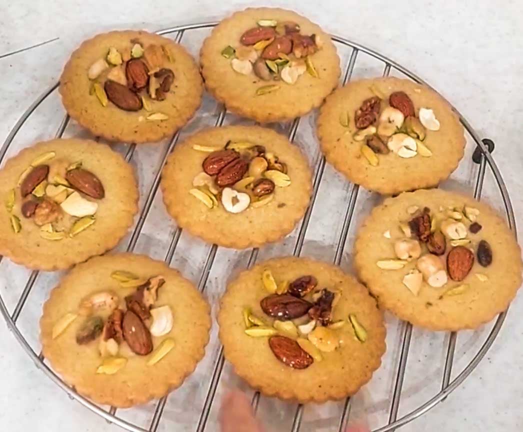 Freshly baked baklava cookies topped with mixed nuts cooling after baking.
