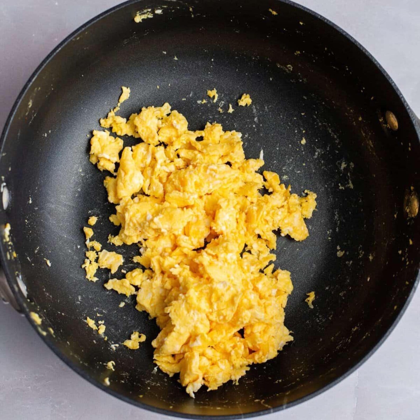 Scrambled eggs cooking in a skillet for Egg Roll in a Bowl.