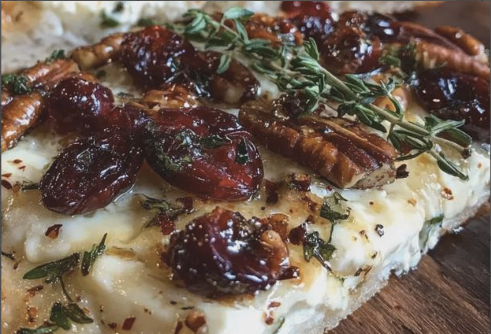 Hot honey drizzled over Brie cranberry pecan flatbread before serving