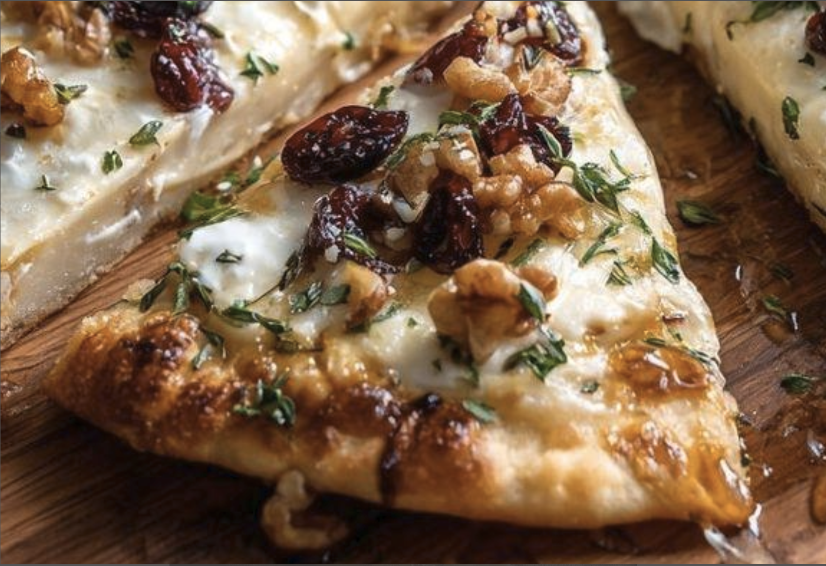 Brie cranberry pecan flatbread sliced into wedges and ready to serve