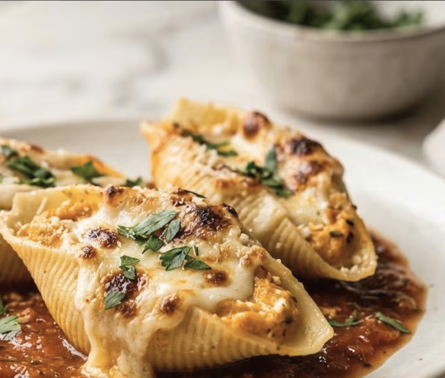 Pumpkin ricotta stuffed shells served with melted cheese and parsley