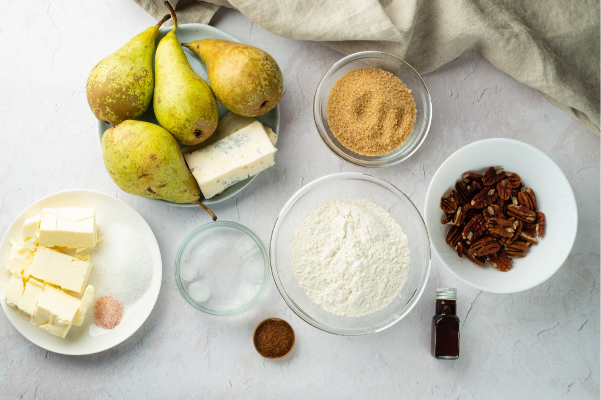 Pears, flour, butter, Gorgonzola cheese, pecans and other ingredients arranged for a homemade pear tart.