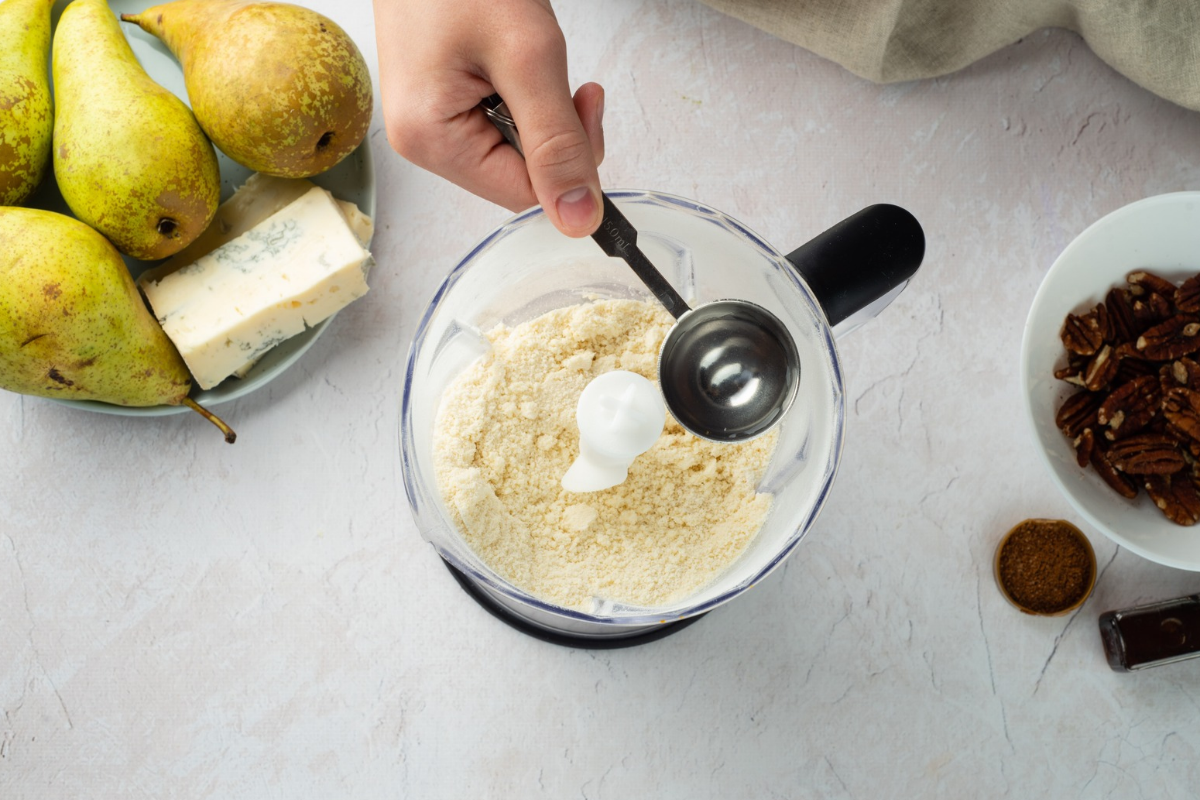 Adding cold butter to flour while preparing homemade tart pastry.
