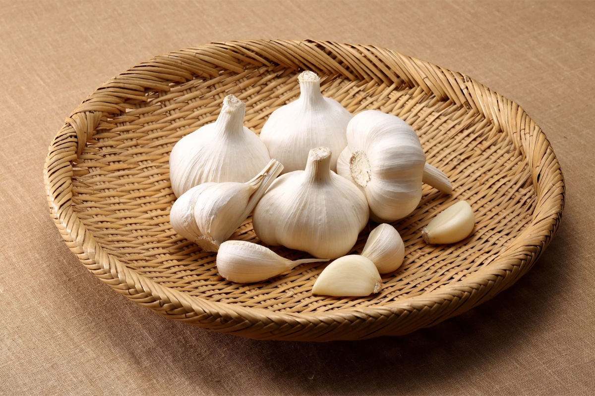 Fresh garlic cloves used to add savory flavor to homemade Mediterranean olive salad with creamy labneh.