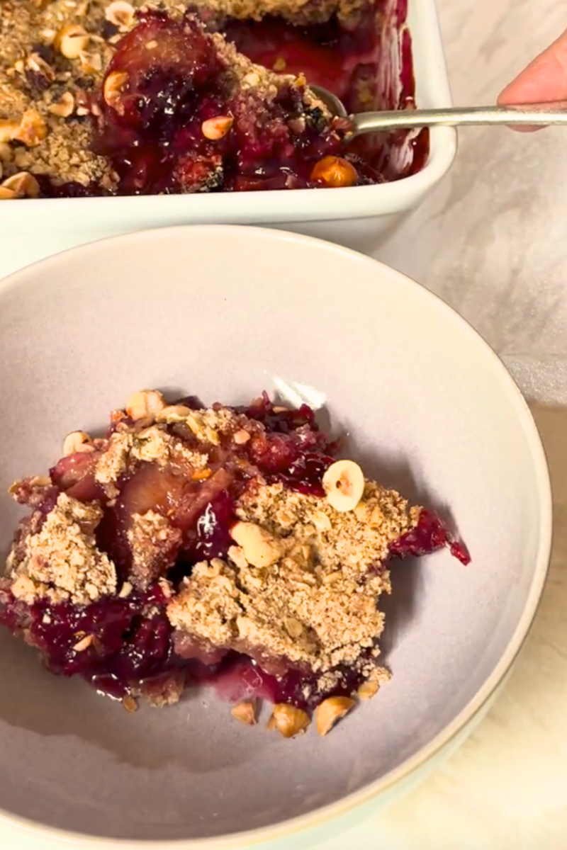 Spiced plum and blackberry crumble with golden oat topping and toasted hazelnuts