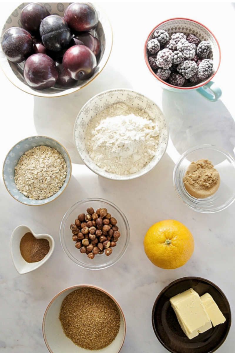 Ingredients for spiced plum and blackberry crumble with toasted hazelnuts