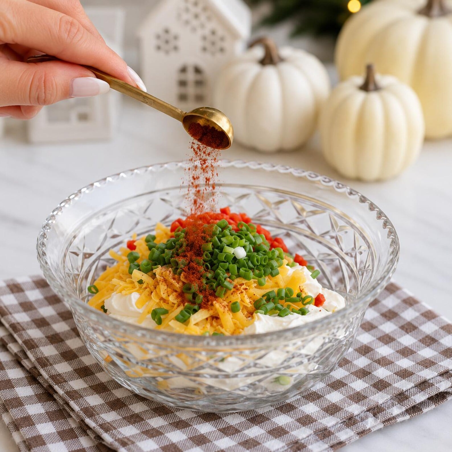 Cream cheese, shredded cheese, green onions, herbs, and seasonings in a mixing bowl for mini pumpkin cheese balls, a festive Fall, Autumn, and Thanksgiving appetizer.